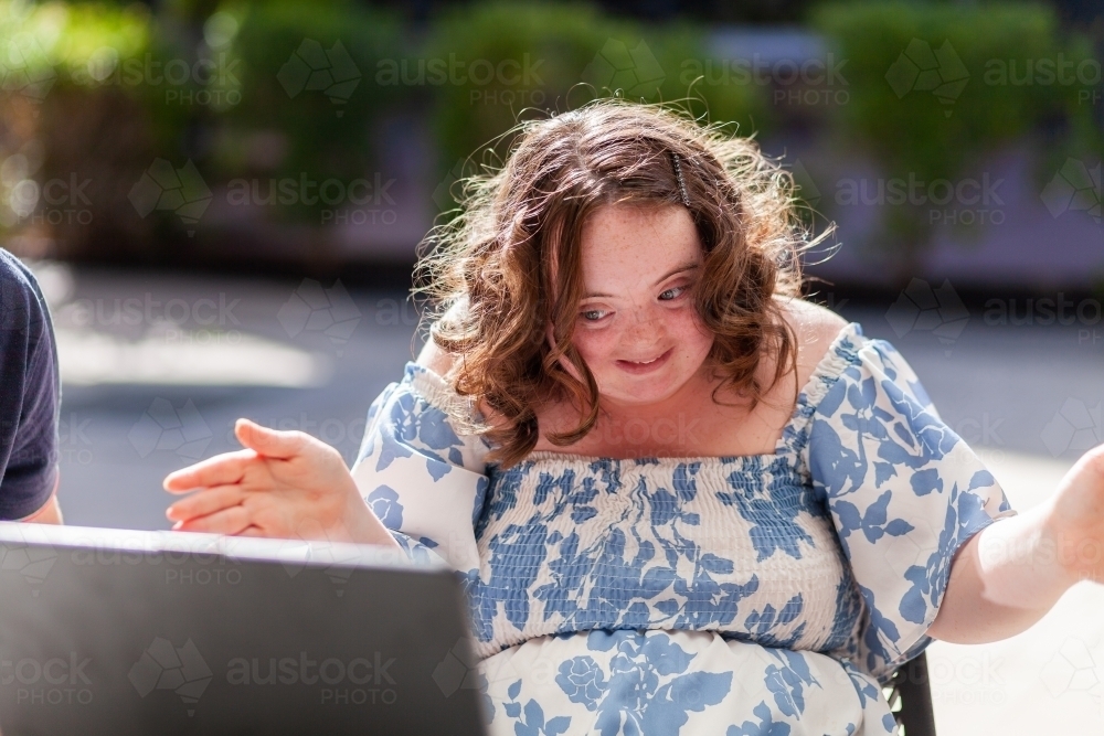 Happy seventeen year old girl with a disability doing a joyful dance move - Australian Stock Image