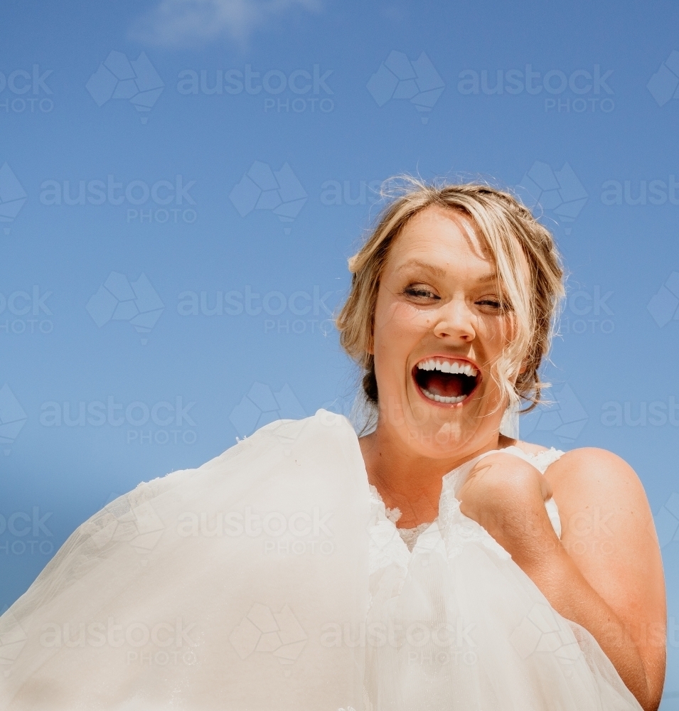 Happy smiling bride against a blue sky. - Australian Stock Image