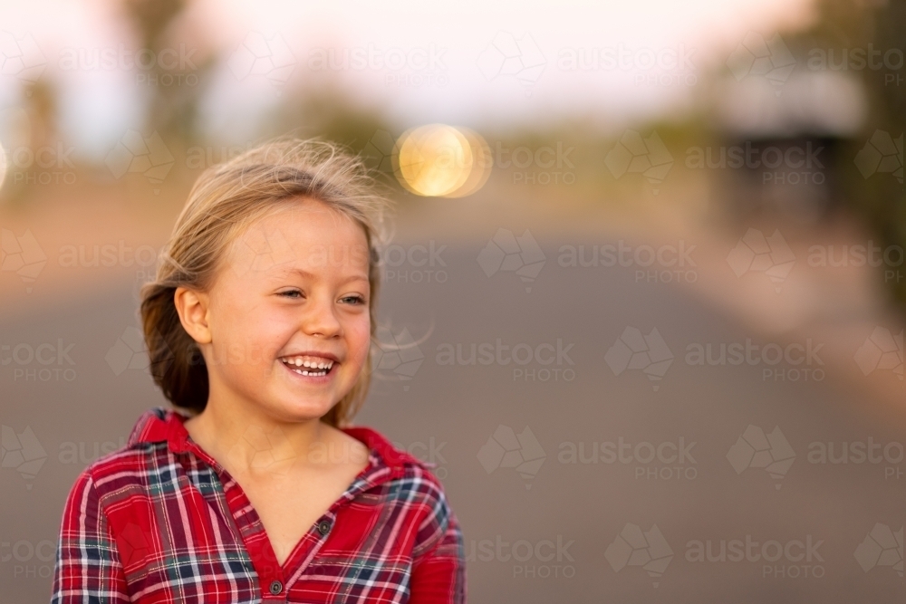 happy smiling little girl outdoors at sunset - Australian Stock Image