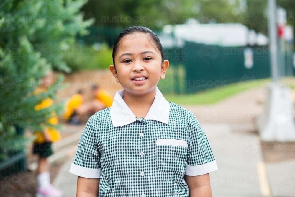 Happy smiling school girl wearing a dress - Australian Stock Image