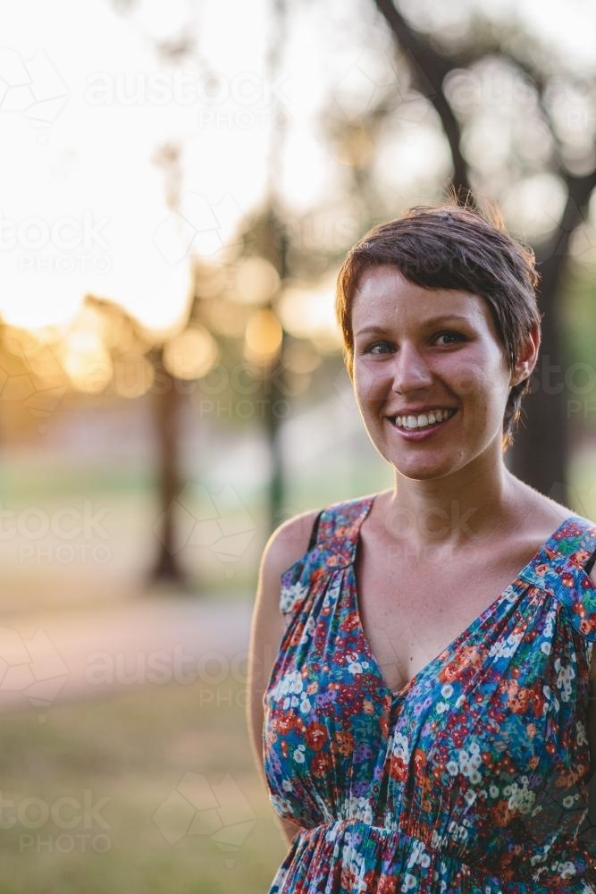 Happy smiling woman in summer dress at dusk - Australian Stock Image