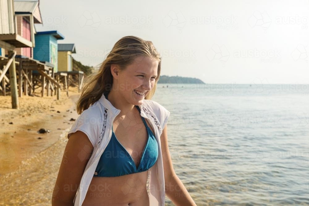 Happy teen girl at the beach wearing a bikini - Australian Stock Image