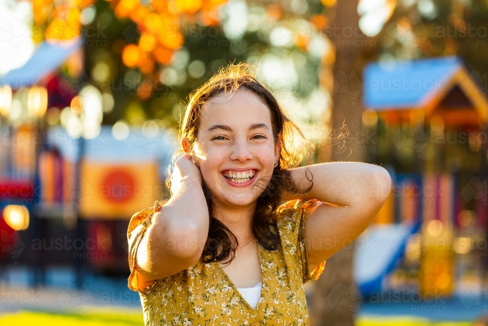 Happy teen girl smiling in golden light - Australian Stock Image