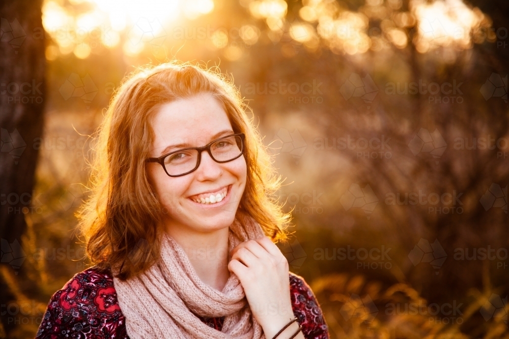 Happy teen girl smiling in golden sunset light outside - Australian Stock Image