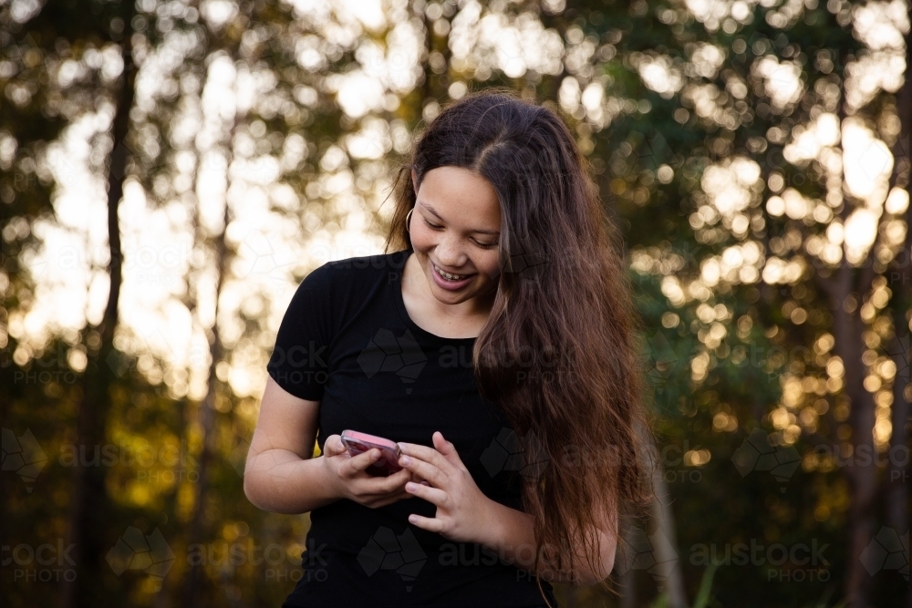 happy teen on phone - Australian Stock Image