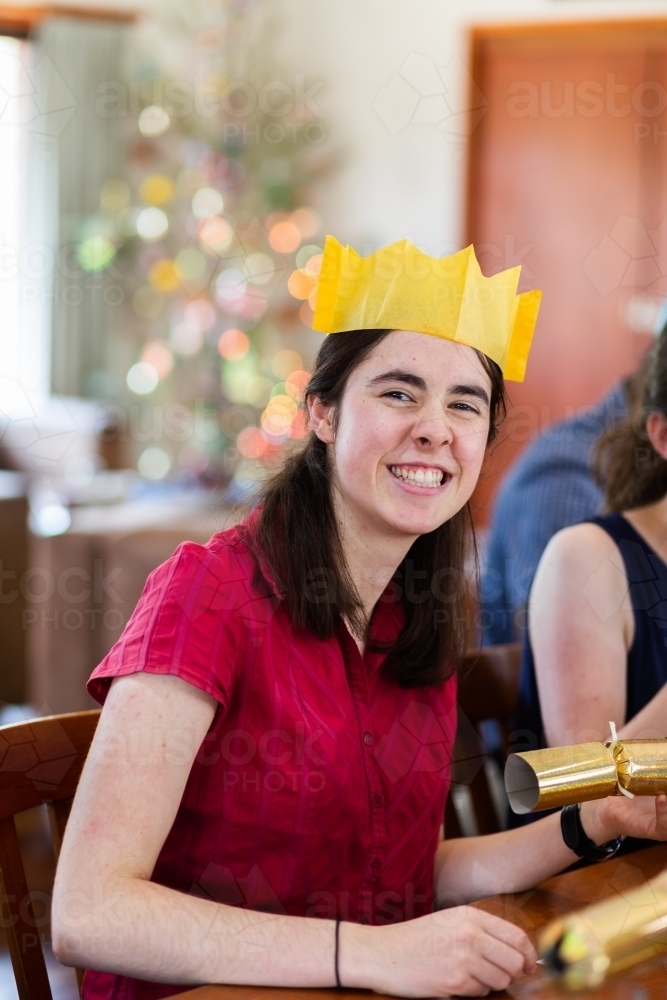 Happy teen person smiling at camera during Christmas lunch celebration - Australian Stock Image