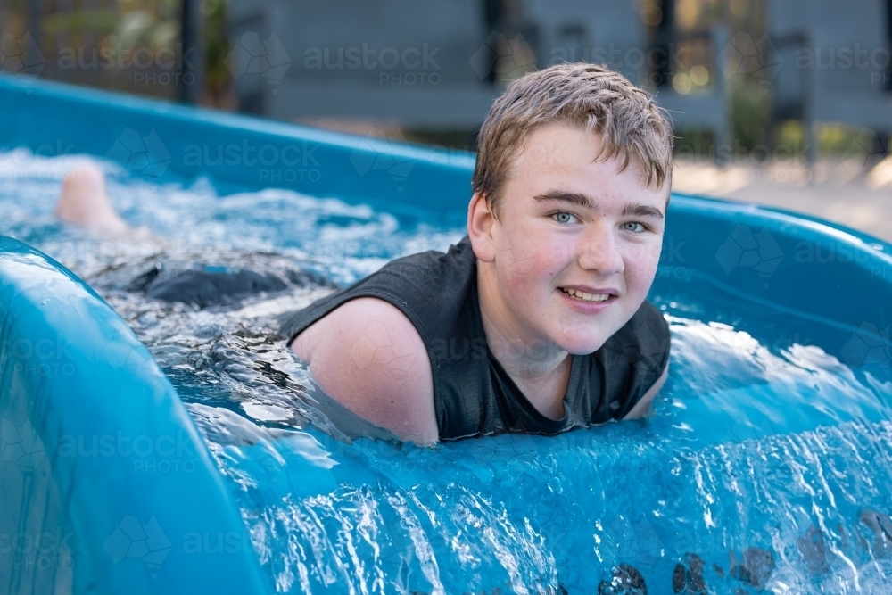 Happy teenage boy having fun at water park - Australian Stock Image