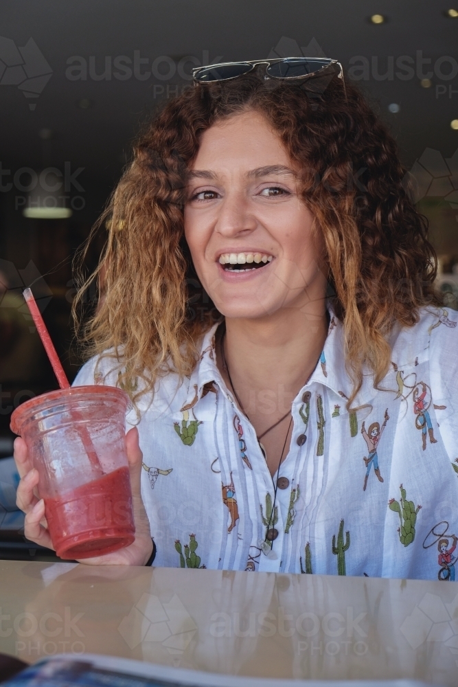 Happy teenage girl at juice bar - Australian Stock Image