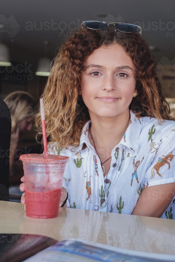 Happy teenage girl at juice bar - Australian Stock Image