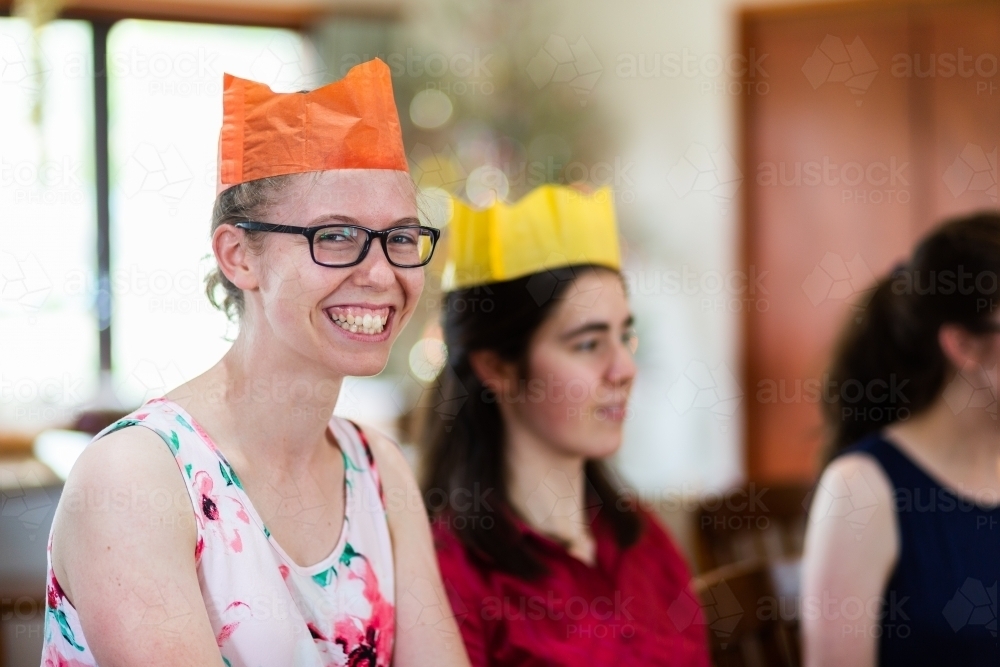 Happy teenage person wearing paper crown hat at Christmas time - Australian Stock Image