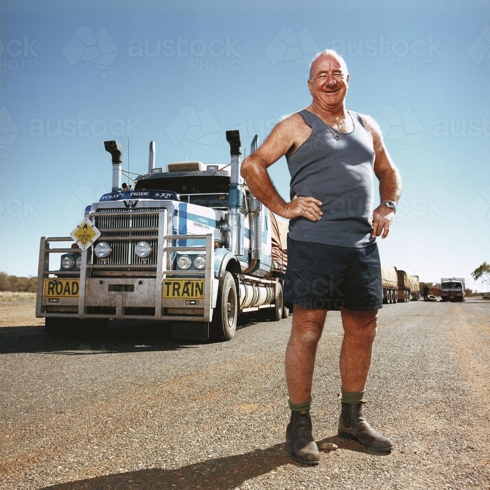 Happy truck driver standing front of road train - Australian Stock Image