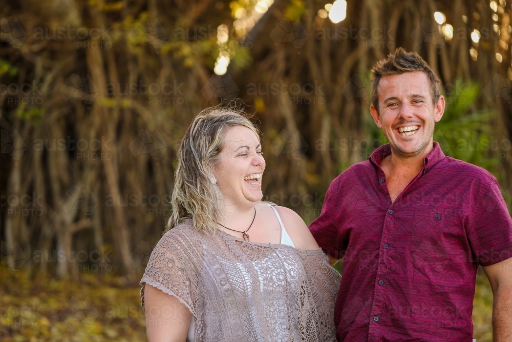 Happy twenty-something couple in golden afternoon light at the park - Australian Stock Image