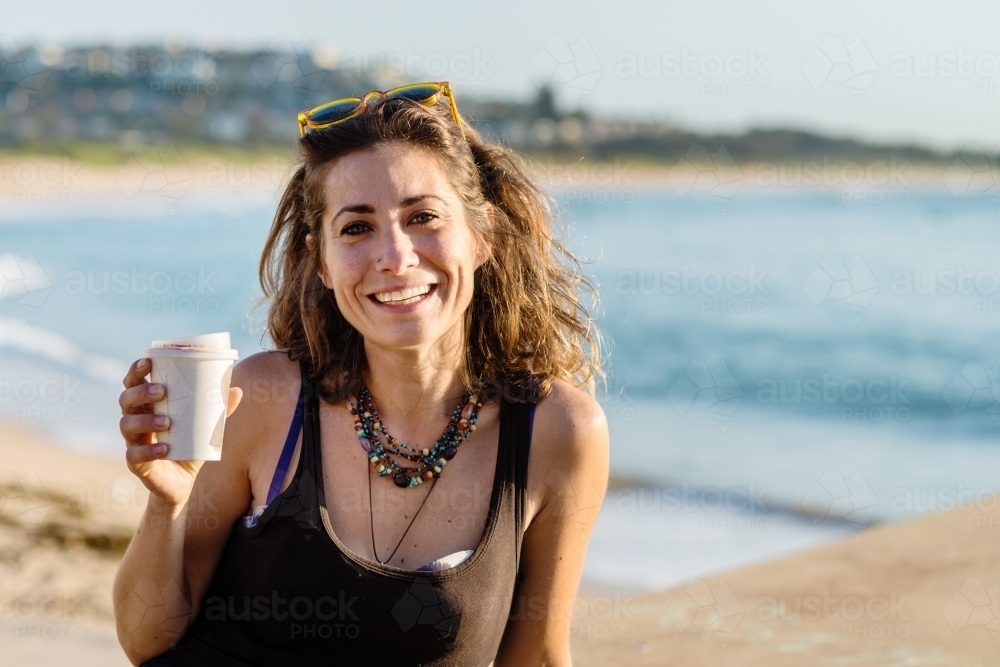 happy woman at beach in the morning with coffee - Australian Stock Image