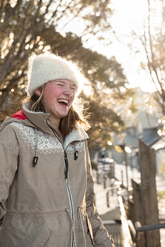 happy woman in ski resort, she is wearing a parka and beanie - Australian Stock Image