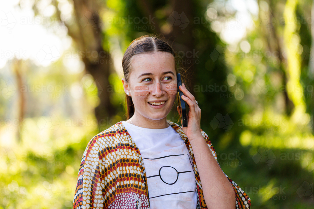 Happy young Aussie person making phone call on mobile device - Australian Stock Image