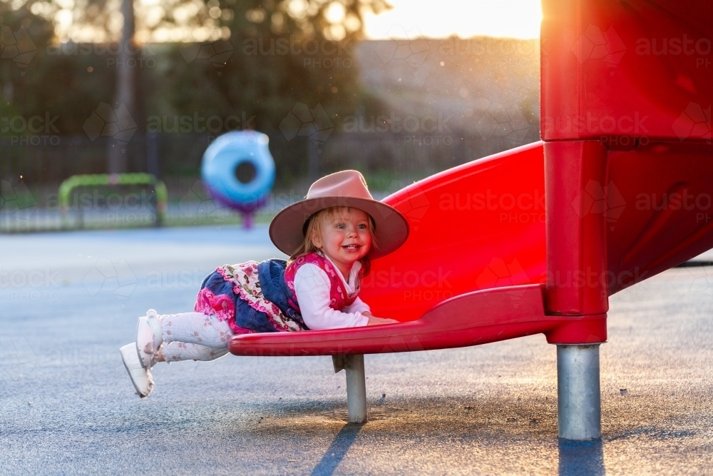 Slippery Dip Ride Image of Happy young Australian girl sliding down slippery dip slide at ...