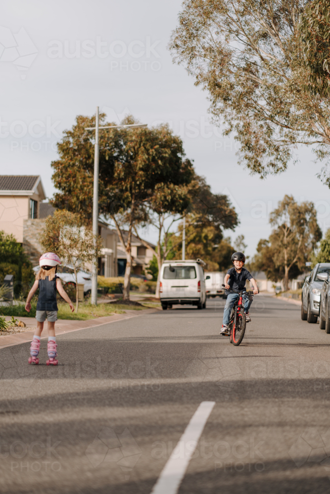 Happy young boy riding his bicycle on the street. - Australian Stock Image
