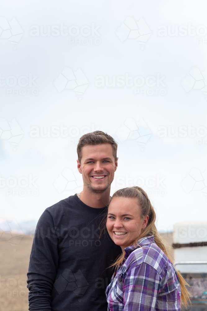 Happy young couple standing closely with each other outdoors - Australian Stock Image