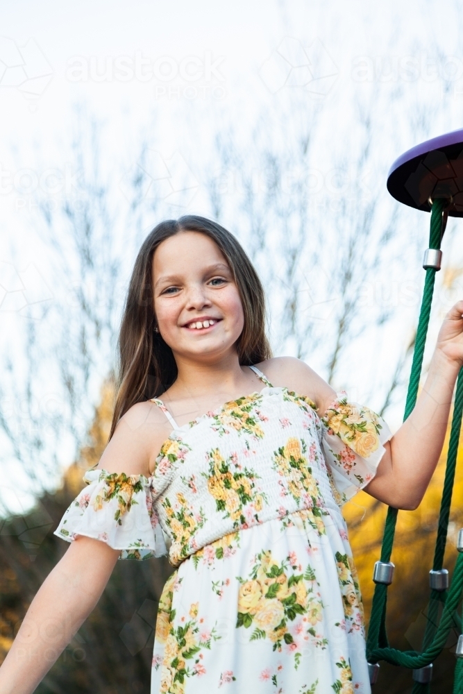 Happy young girl playing on equipment at park - Australian Stock Image