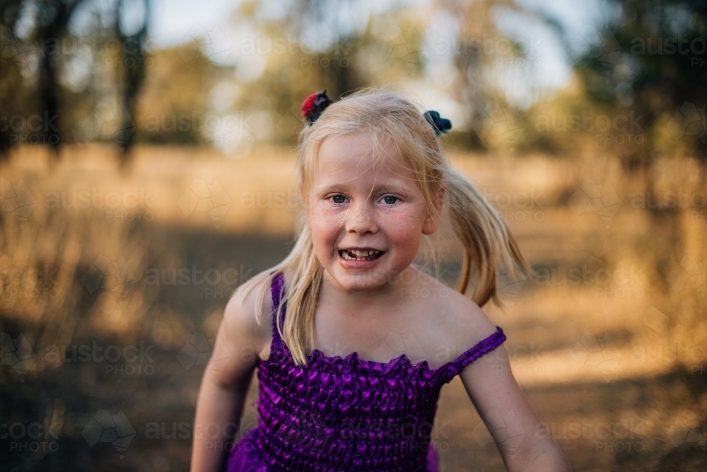 Happy young girl playing outside - Australian Stock Image