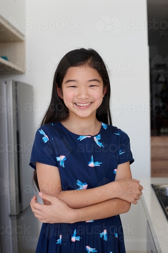 Happy young Japanese girl in kitchen - Australian Stock Image