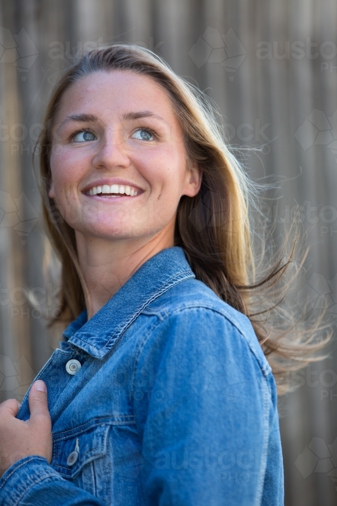 Happy Young Woman in Denim Jacket - Australian Stock Image