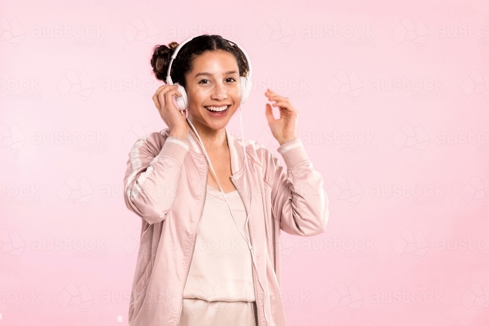 Happy young woman, listening to music on headphones & dancing. - Australian Stock Image