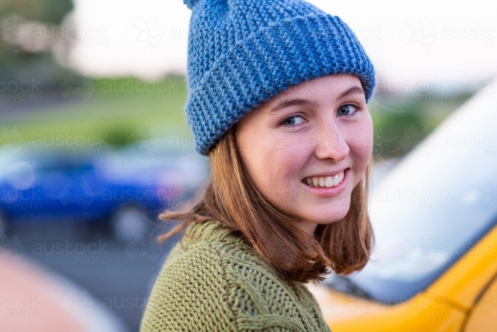 happy young woman wearing hand knitted beanie - Australian Stock Image