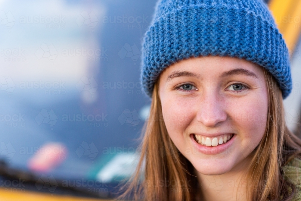 happy young woman wearing hand knitted beanie - Australian Stock Image