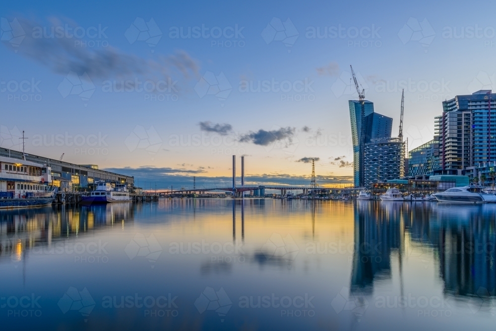 Harbour view with modern buildings and reflections at sunset, in Dockland - Australian Stock Image