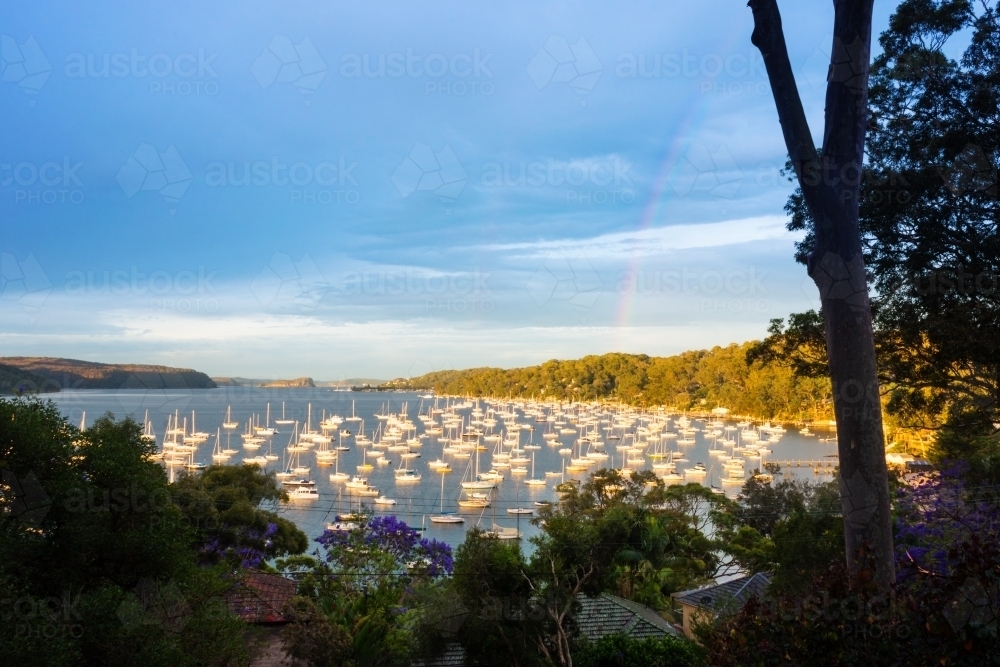 harbour with yachts, and rainbow - Australian Stock Image