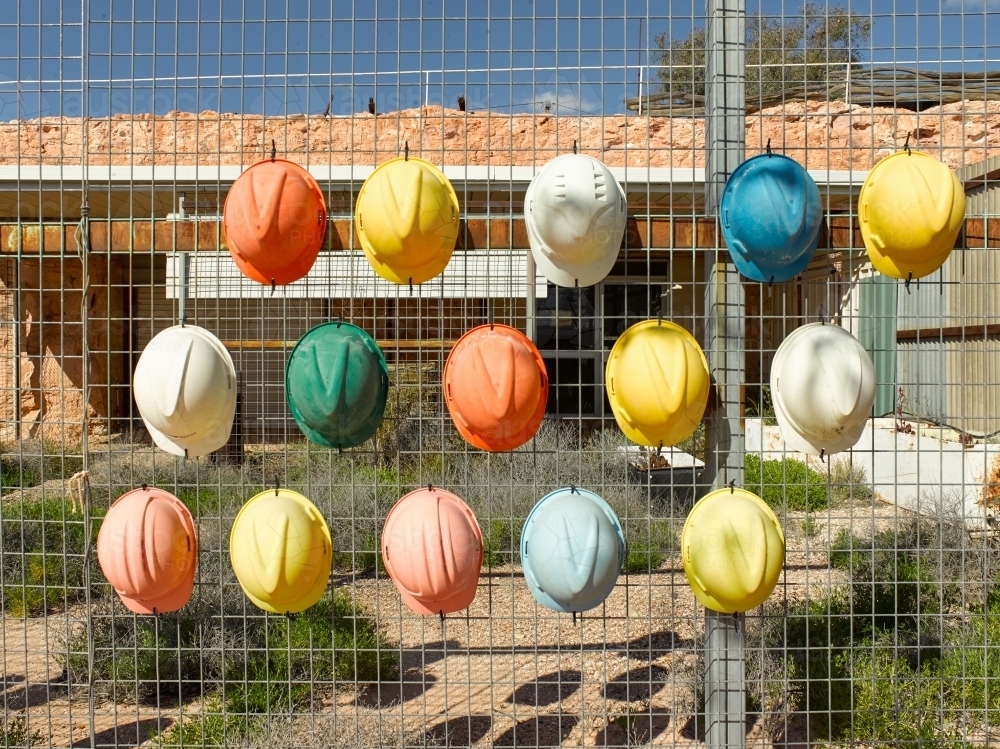 Hard hats on fence at a tourist mine - Australian Stock Image