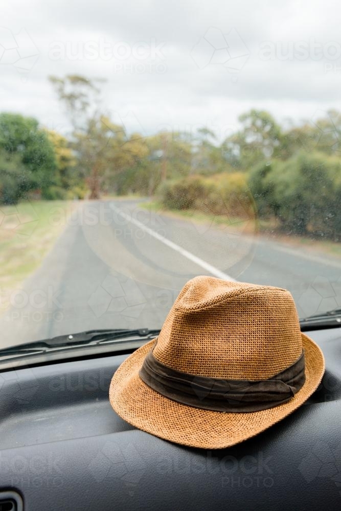 hat on the dashboard of a car on a road trip - Australian Stock Image