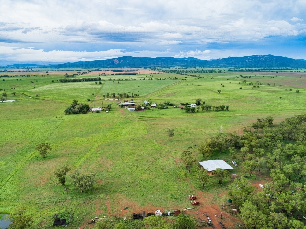 Hay shed on farm with distant homestead buildings and paddocks - Australian Stock Image