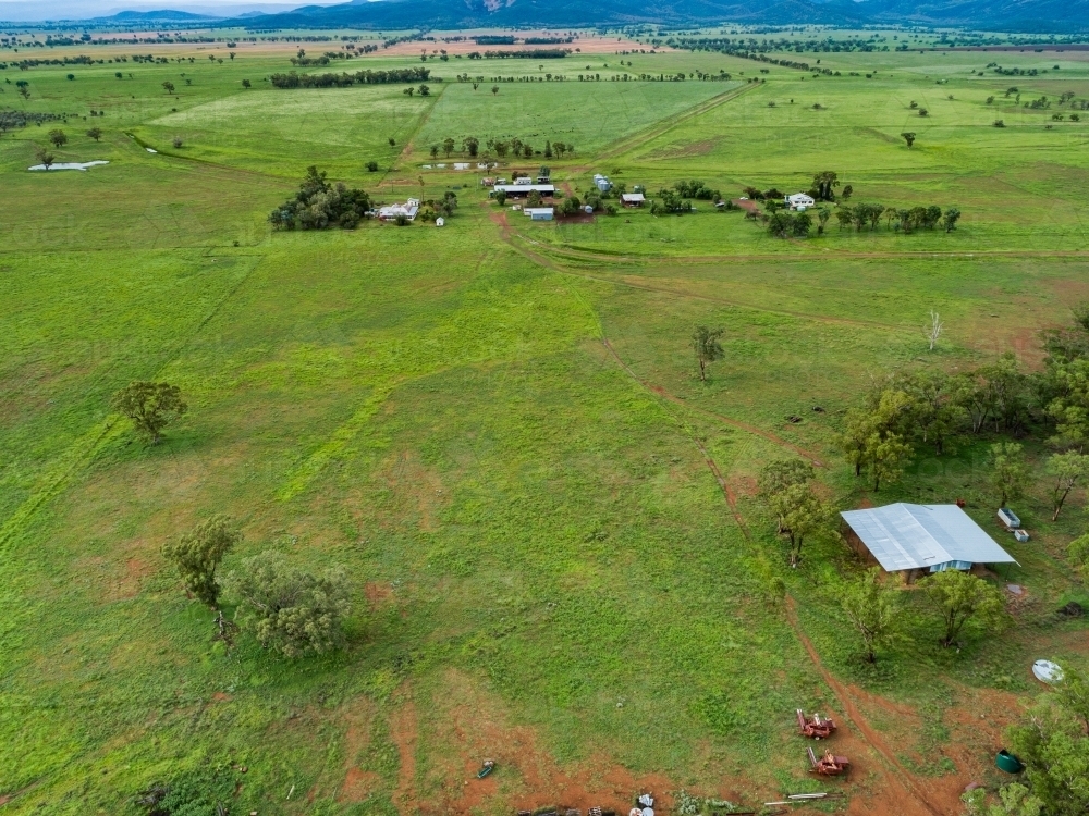 Hay shed on farm with distant homestead buildings and paddocks - Australian Stock Image