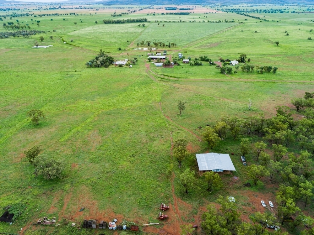 Hay shed on farm with distant homestead buildings and paddocks - Australian Stock Image