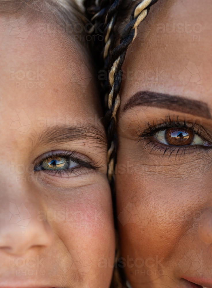 Hazel and brown eyes of First Nations Australian girl and mother with faces close together - Australian Stock Image