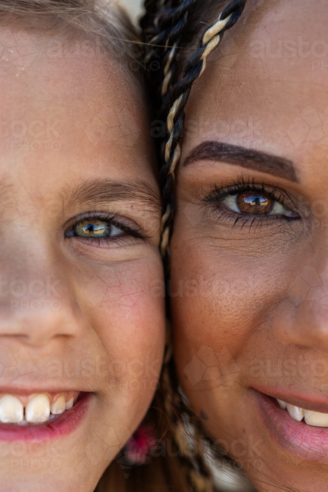 Hazel and brown eyes of First Nations Australian girl and mother with faces close together - Australian Stock Image