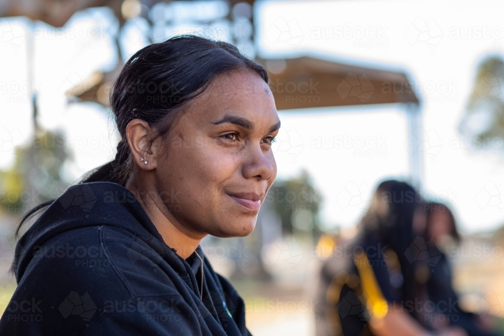head and shoulders of aboriginal girl with more blurred in background - Australian Stock Image