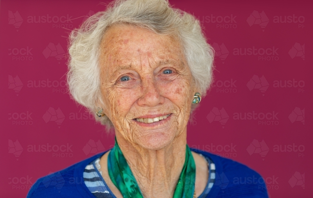 head and shoulders of elderly lady with grey hair looking at camera - Australian Stock Image