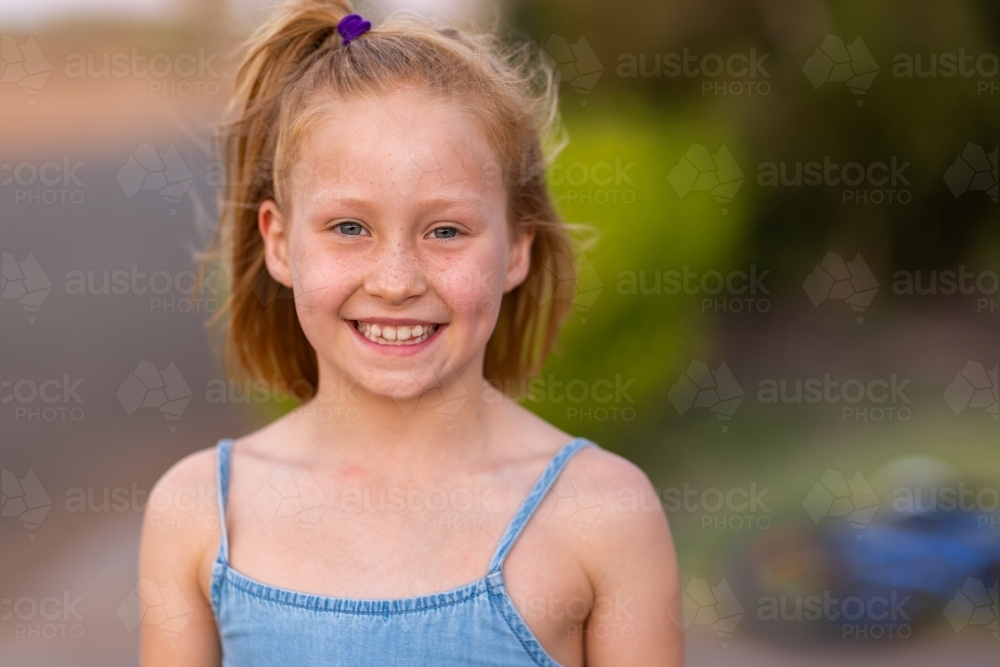head and shoulders of fair little girl smiling - Australian Stock Image