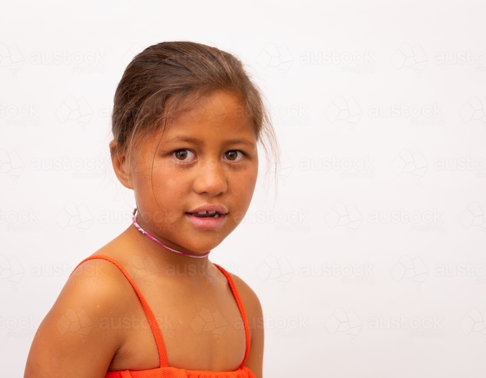 head and shoulders of little girl against white background - Australian Stock Image