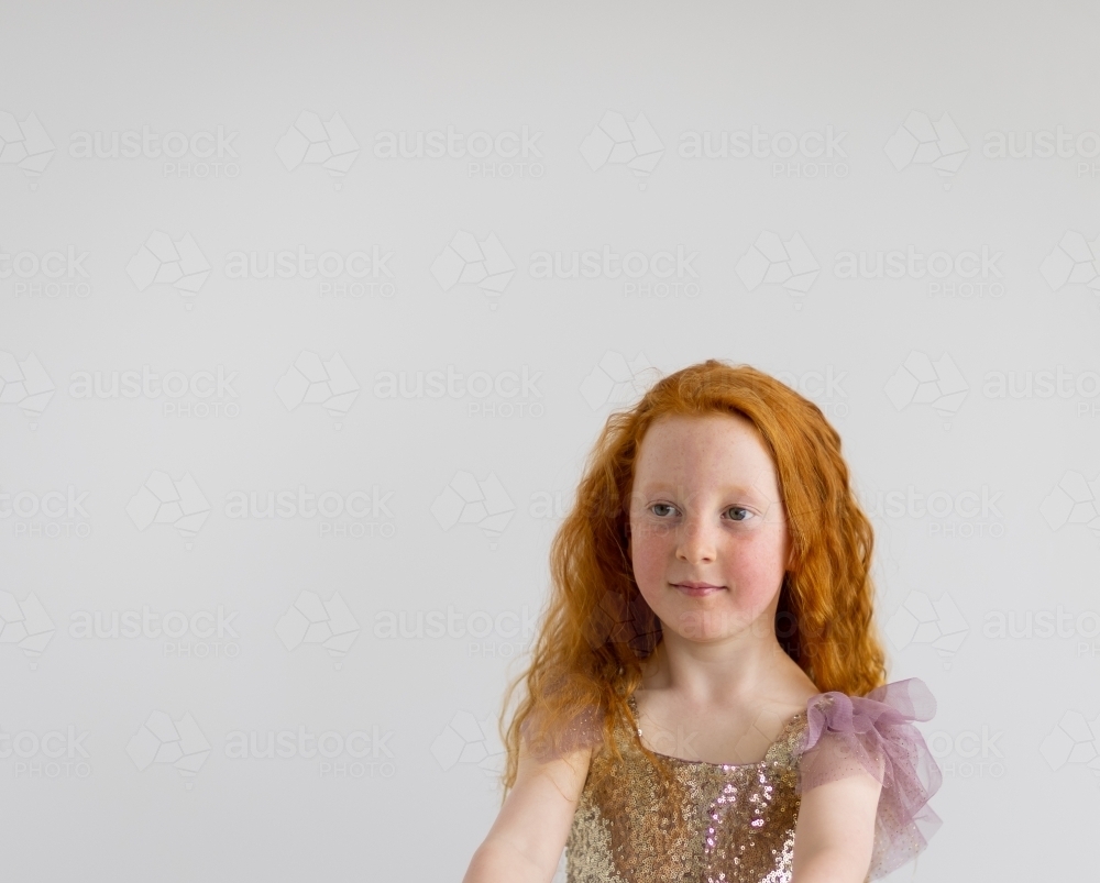 head and shoulders of little girl wearing sequinned dress - Australian Stock Image