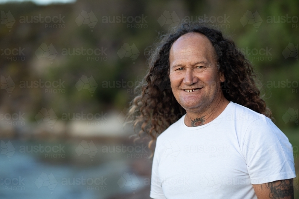 head and shoulders of long-haired man at beach with copy space - Australian Stock Image