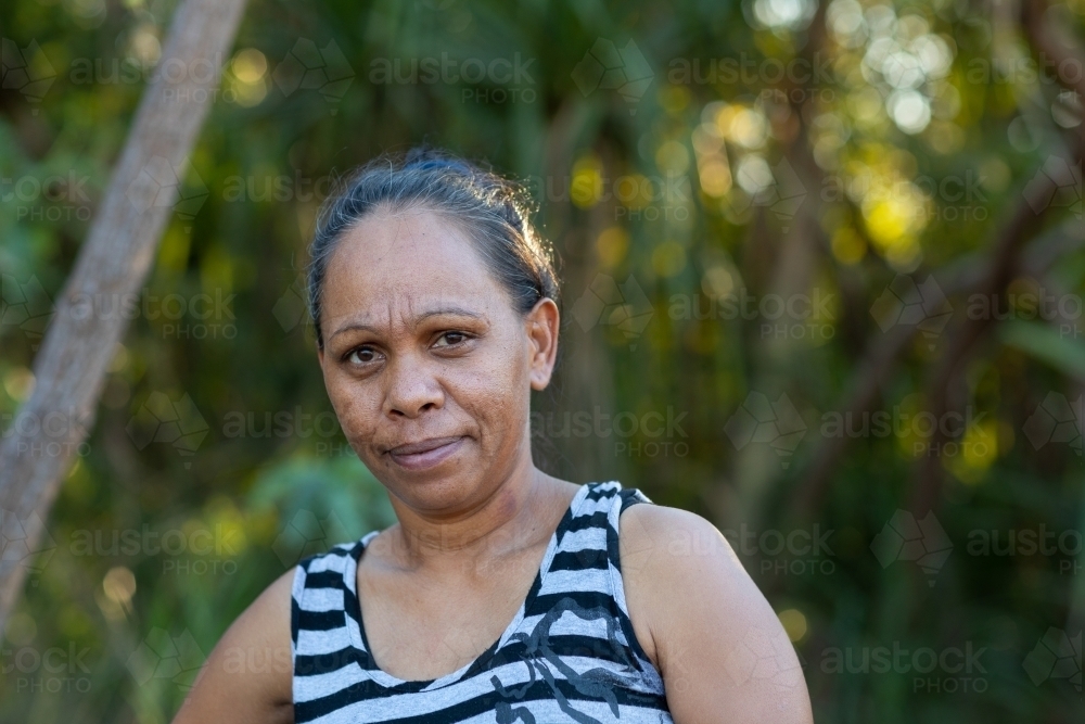 head and shoulders of mature woman wearing  striped singlet outdoors - Australian Stock Image