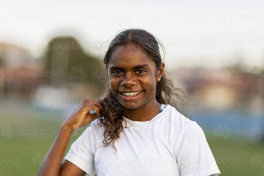 head and shoulders of one aboriginal girl smiling - Australian Stock Image
