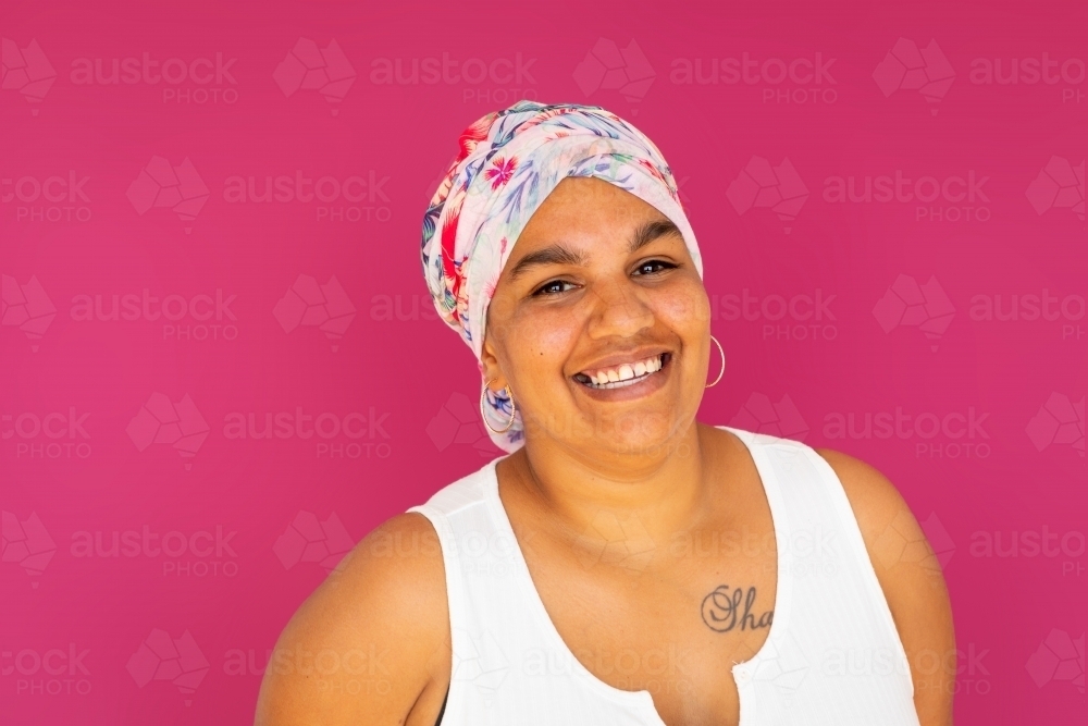 head and shoulders of smiling indigenous woman wearing head wrap - Australian Stock Image