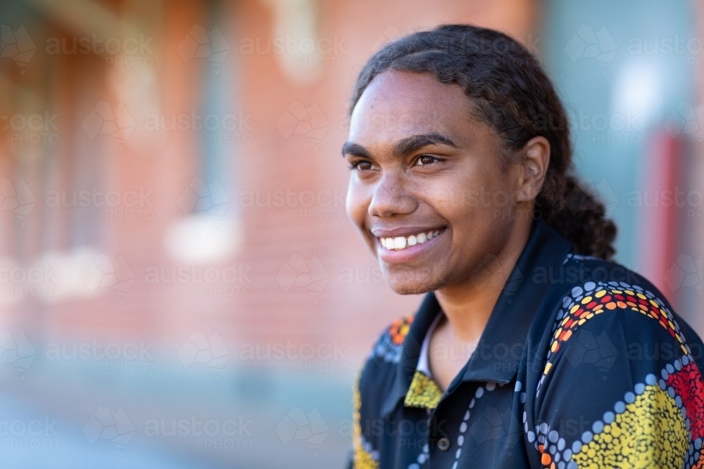 head and shoulders of smiling teenager with hair tied back - Australian Stock Image