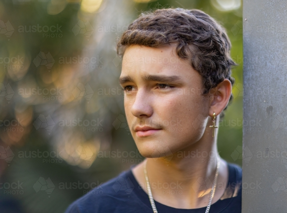 head and shoulders of teen boy looking away - Australian Stock Image