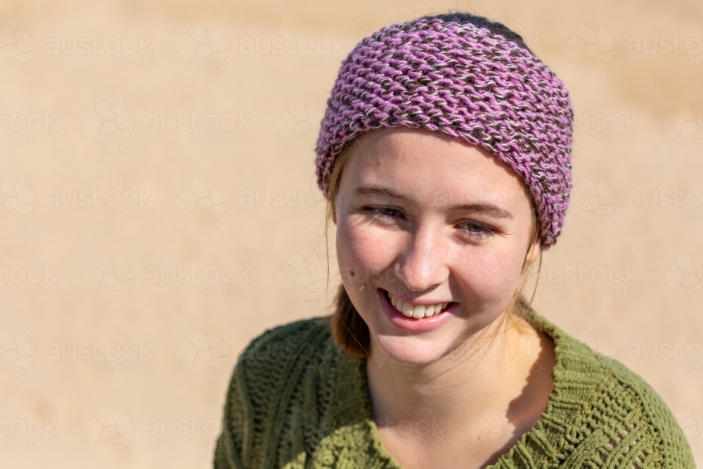 head and shoulders of teen girl with knitted headband in sunshine - Australian Stock Image